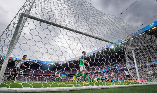 Tysklands Mesut Özil (tv) jublar när Mario Gomez (th) gör 0-1 bakom Nordirlands målvakt Michael McGovern (m) i fotbollsmatchen mellan Nordirland och Tyskland