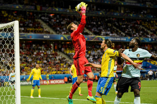 Sveriges målvakt Andreas Isaksson plockar bollen framför Erik Johansson och Belgiens Romelu Lukaku  fotbollsmatchen mellan Sverige och Belgien