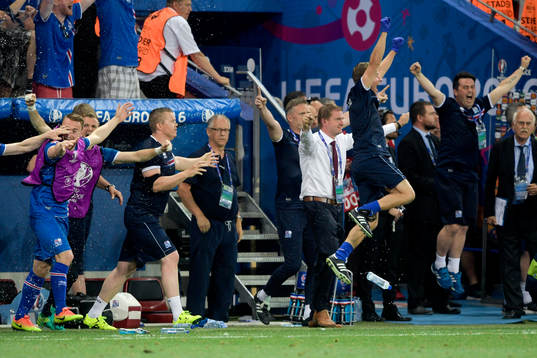Islands förbundskapten Lars Lagerbäck i mitten av jublande spelare efter fotbollsmatchen mellan England och Island