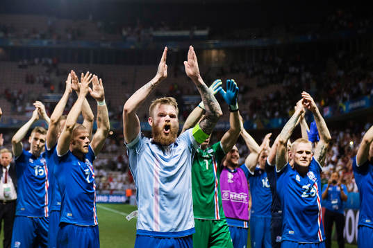 Islands spelare med Aron Gunnarsson längst fram jublar efter fotbollsmatchen mellan England och Island