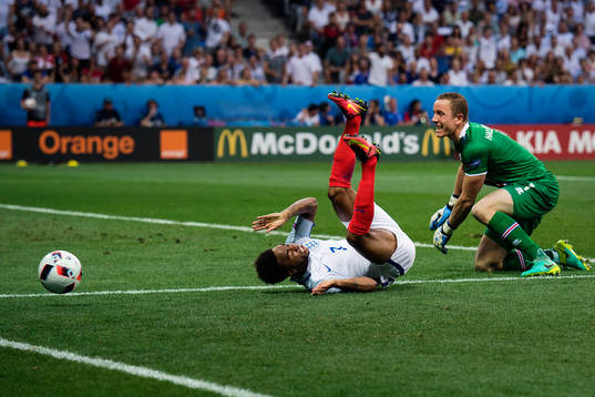 Englands Raheem Sterling faller i en duell med Islands