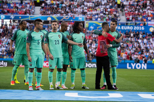 En person tar sig in och kramar Portugals Cristiano Ronaldo