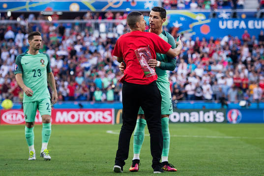 En person tar sig in och kramar Portugals Cristiano Ronaldo