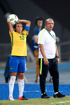 Brasiliens Marta kastar ett inkast jämte förbundskapten