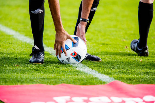 Domaren plockar upp matchbollen