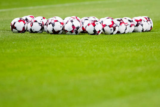 Flera fotbollar ligger på planen