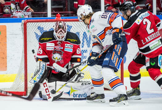 Växjös Adam Brodecki med pucken framför  Malmö Redhawks