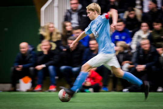 Spelare jagar boll i rörelseoskärpa