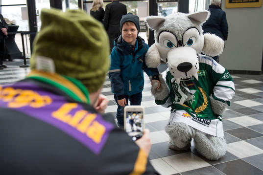 En pojke tar en bild ihop med Färjestads maskot Ture Varg