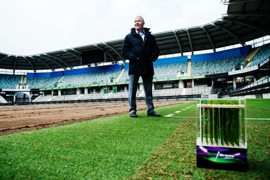 I Turf Managements Andy Cole poserar för ett porträtt med en modell av hybridgräset