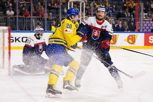 Sveriges Elias Lindholm blir tacklad av Slovakiens Vladimir