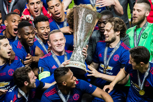 Manchester Uniteds Wayne Rooney håller upp pokalen och jublar tillsammans med sina lagkamrater