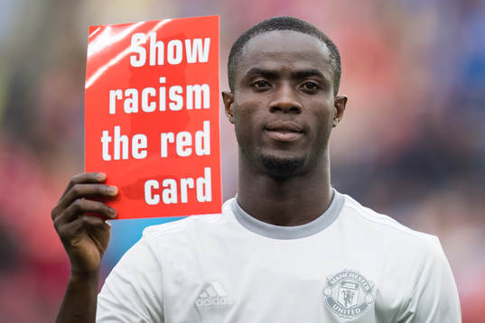 Manchester Uniteds Eric Bailly med en lapp där det står 