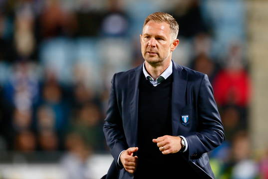 Malmö FFs suppers har klättrat in till planens kant och manas bort av Malmös FFs tränare Magnus Pehrsson som springer över planen