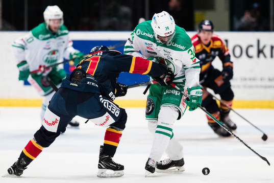 Djurgårdens Markus Ljungh i kamp om pucken med Rögles