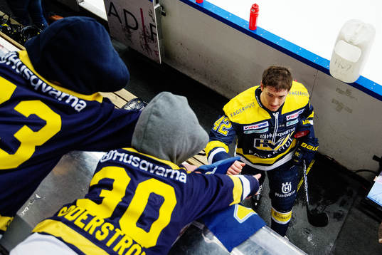 Två unga HV71-supportrar sträcker händerna mot Dylan