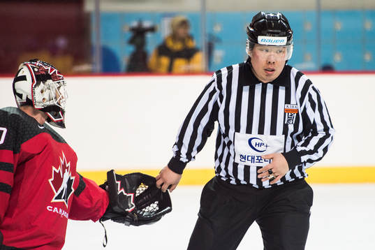 The referee and Goaltender Ben Scrivens of Canada