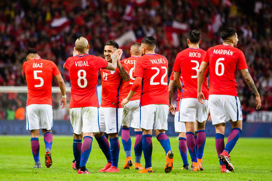 a vänster) gör 1-2 och gratuleras närmast av Arturo Vidal under träningslandskampen i fotboll mellan Sverige och Chile den 24 Mars 2018 i Stockholm. 