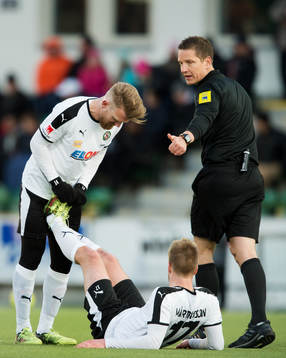 Örebros Michael Almebäck hjälper Johan Mårtensson som fått kramp och domare Markus Strömbergsson gör tummen upp