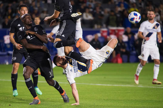 LA Galaxys Romain Alessandrini utmanar Kansas Ike Opara och Graham Zusi när han försöker sig på en bicykleta