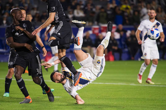 LA Galaxys Romain Alessandrini utmanar Kansas Ike Opara och Graham Zusi när han försöker sig på en bicykleta