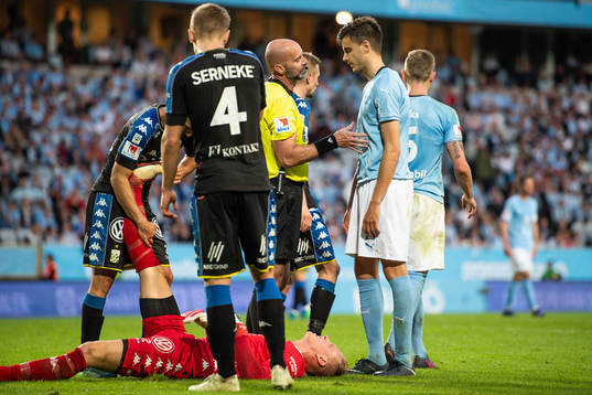 IFK Göteborgs målvakt Pontus Dahlberg ligger ner efter en duell medan domare Stefan Johannesson diskuterar med Malmö FFs Alexander Jeremejeff