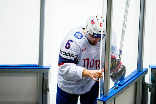 Jonas Holøs of Norway goes off the ice with an injury