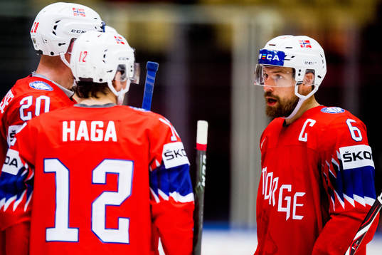 Jonas Holøs of Norway talks to teammates Anders Bastiansen