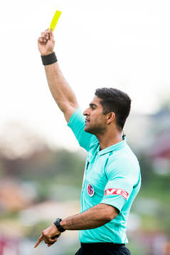Mohammad Usman Aslam, referee, shows a yellow card