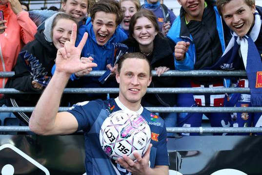 Tommy Høiland of Viking celebrates with the matchball and Viking supporters after scoring 3 goals