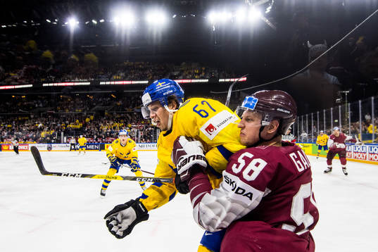 Sveriges Rickard Rakell tacklar Lettlands Guntis Galvins