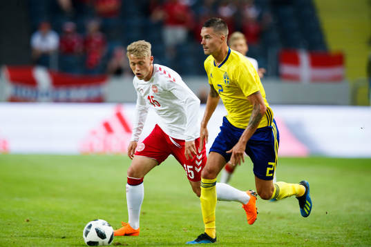 Danmarks målvakt Jonas Lössl jagar Sveriges Mikael Lustig