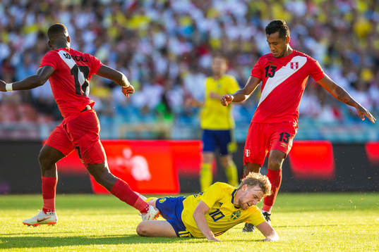 Emil Forsberg of Sweden falls in a duell with Luis Advincula and Renato Tapia of Peru