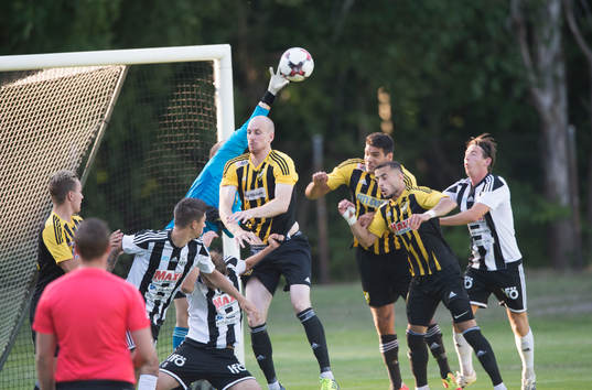 IFK Hässleholms målvakt Adam Larsson boxar bort framför Simon Henningsson, Tommy Filipovic och Mohamed Hamdan i matchen i division 2 mellan Bromölla och IFK Hässleholm i Bromölla 28 juni 2018.  