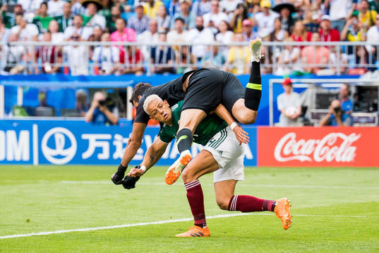 Goalkeeper Alisson of Brazil and Javier Hernandez of Mexico
