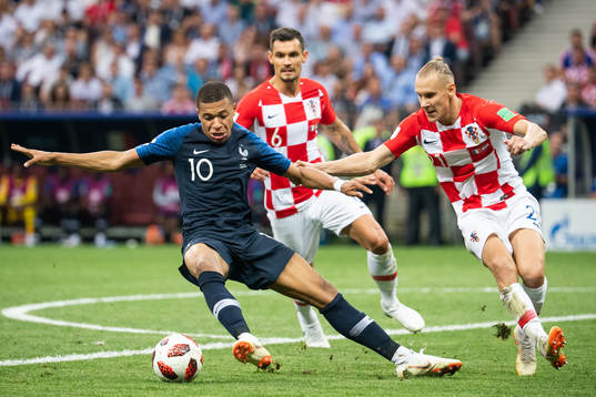 Kylian Mbappe of France competes for the ball with Domagoj
