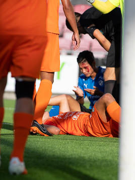 Halmstads Kosuke Kinoshita blodig i bakgrunden efter en situation i AFC Eskilstunas straffområde