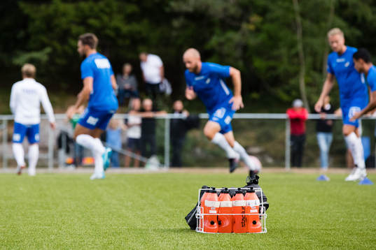Vattenflaskor står på konstgräset när Norrköping värmer upp