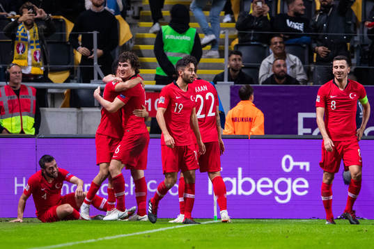 Emre Akbaba of Turkey celebrates with team mates after 3-2