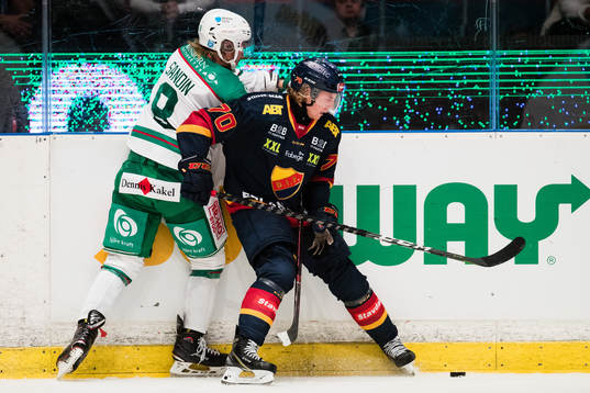 Rögles Linus Sandin i kamp om pucken med Djurgårdens