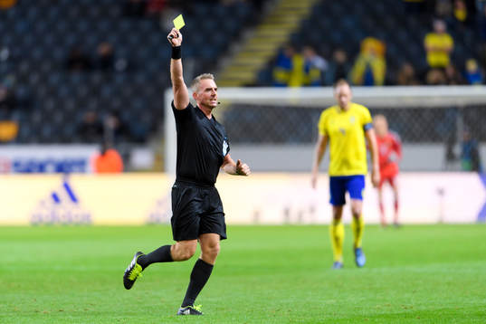 Referee Jakob Kehlet shows the yellow card
