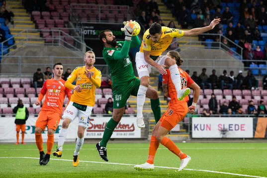 AFC Eskilstunas målvakt Gianluca Curci tar hand om bollen framför Falkenbergs Zlatan Krizanovic