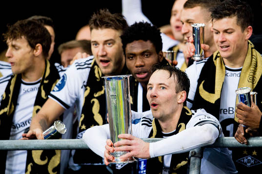 Mike Jensen of Rosenborg lifts the trophy in front of teammates Nicklas Bendtner, Igho Ogbu and Pål André Helland
