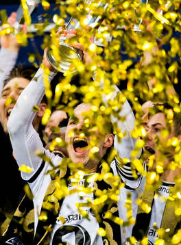 Mike Jensen of Rosenborg lifts the trophy in front of teammates Nicklas Bendtner and Pål André Helland
