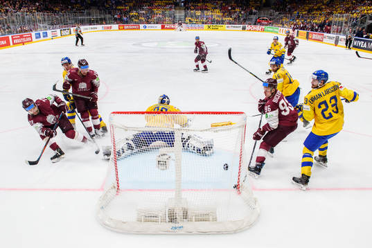 Janis Jaks of Latvia score the 2-3 goal behind goaltender