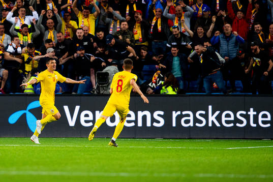 Claudiu Keseru of Romania celebrates with teammates after the 2-2 goal
