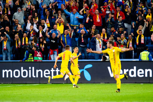 Claudiu Keseru of Romania celebrates with teammates after the 2-2 goal