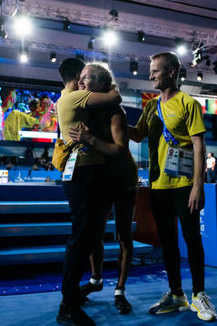 Sofia Mattsson of Sweden (red) is embraced by head coach Sara Dikanda Eriksson and coach Patrik Magnusson after winning against Yulia Khavaldzhy of Ukraine (blue, not pictured) in the Women´s -53 kg Wrestling Final
