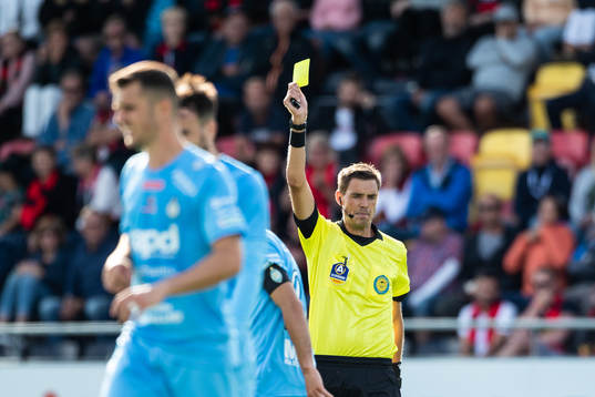 huvuddomare Magnus Lindgren visar ett gult kort för AFC