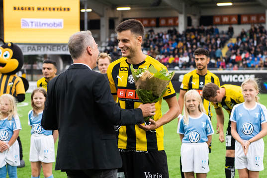 Häckens sportchef Sonny Karlsson delar ut blommor till Alexander Jeremejeff för att fira att han gör sin hundrade match